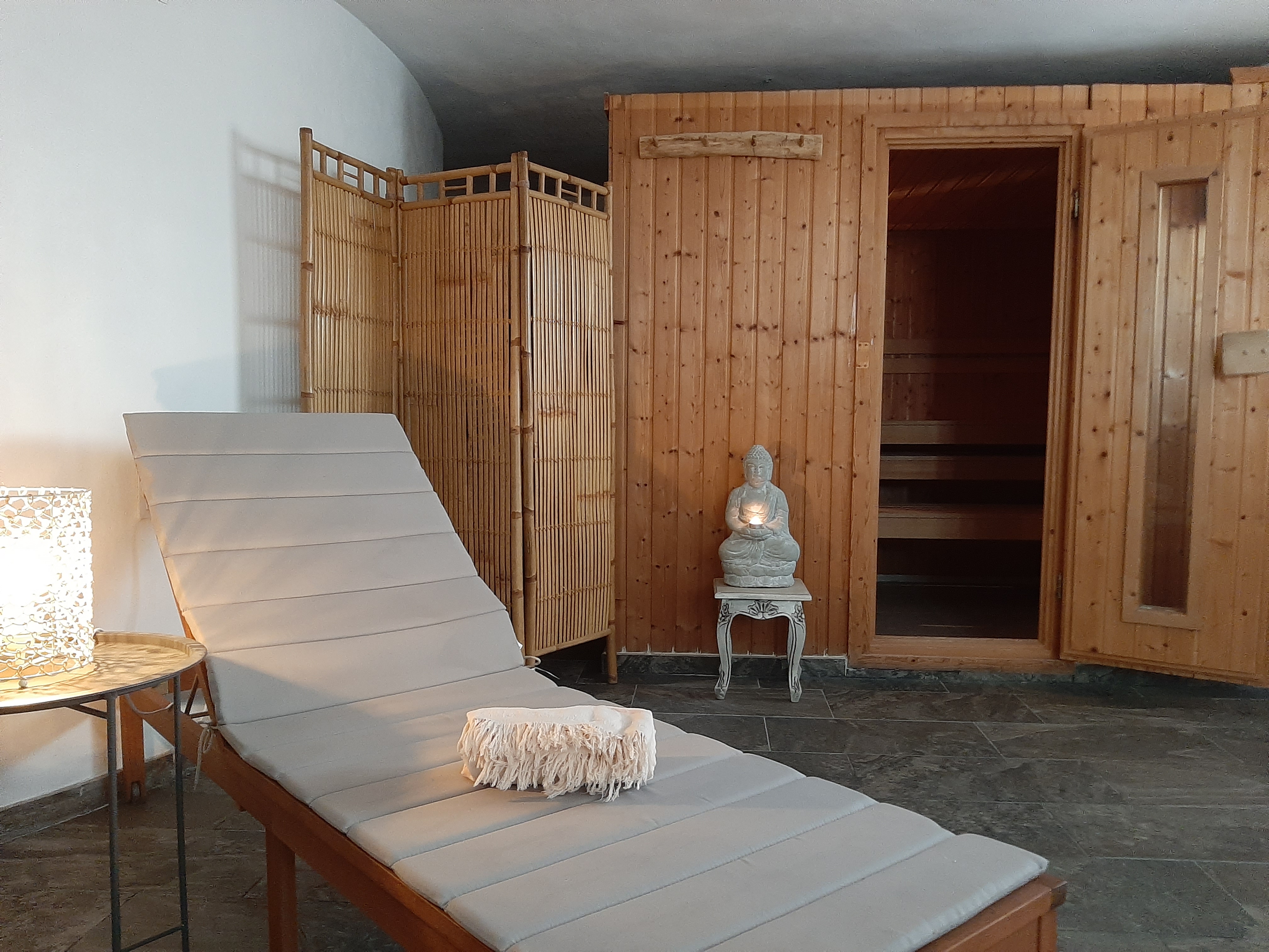 Houten sauna met ligstoel en sfeervolle ontspanningsruimte