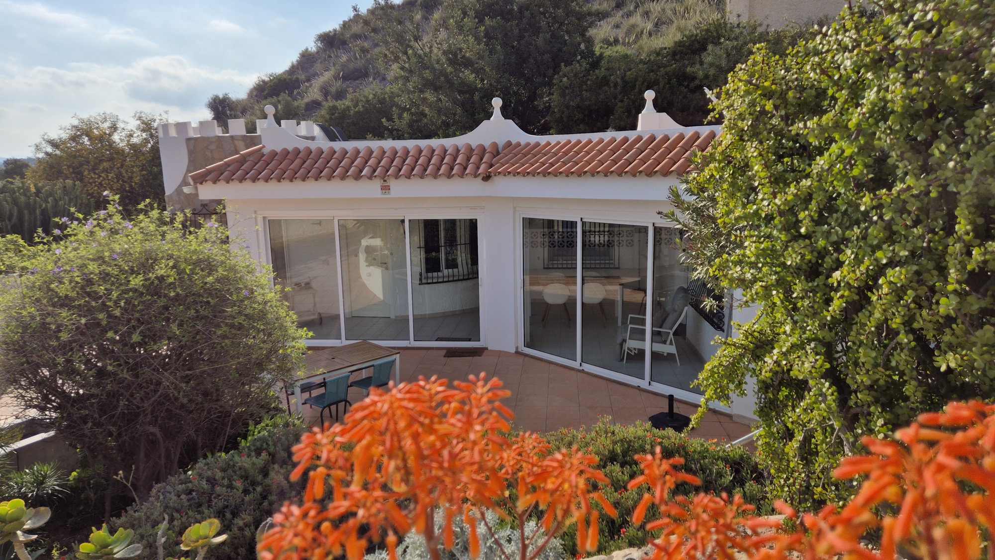 Witte zelfstandige woning omringd door bloeiende mediterrane beplanting